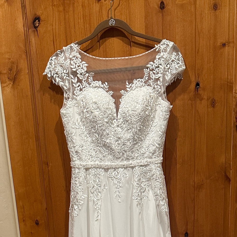 NWT Stunning white wedding dress with intricate lace details. $250